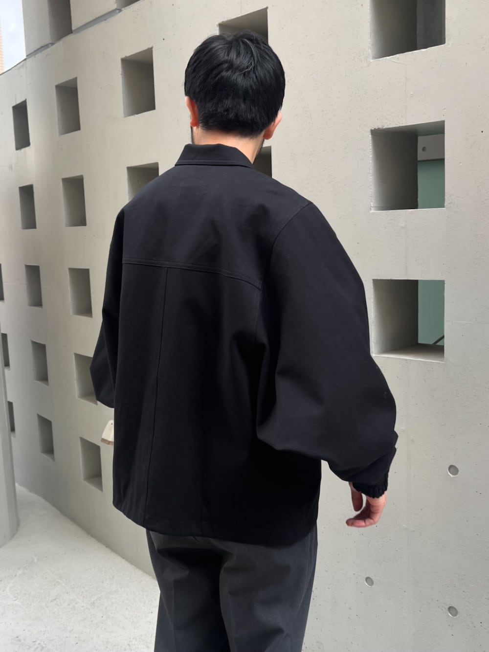 グレー系のその他パンツ、ブラック系のブルゾンを着用したメンズの春コーディネートの3枚目の写真