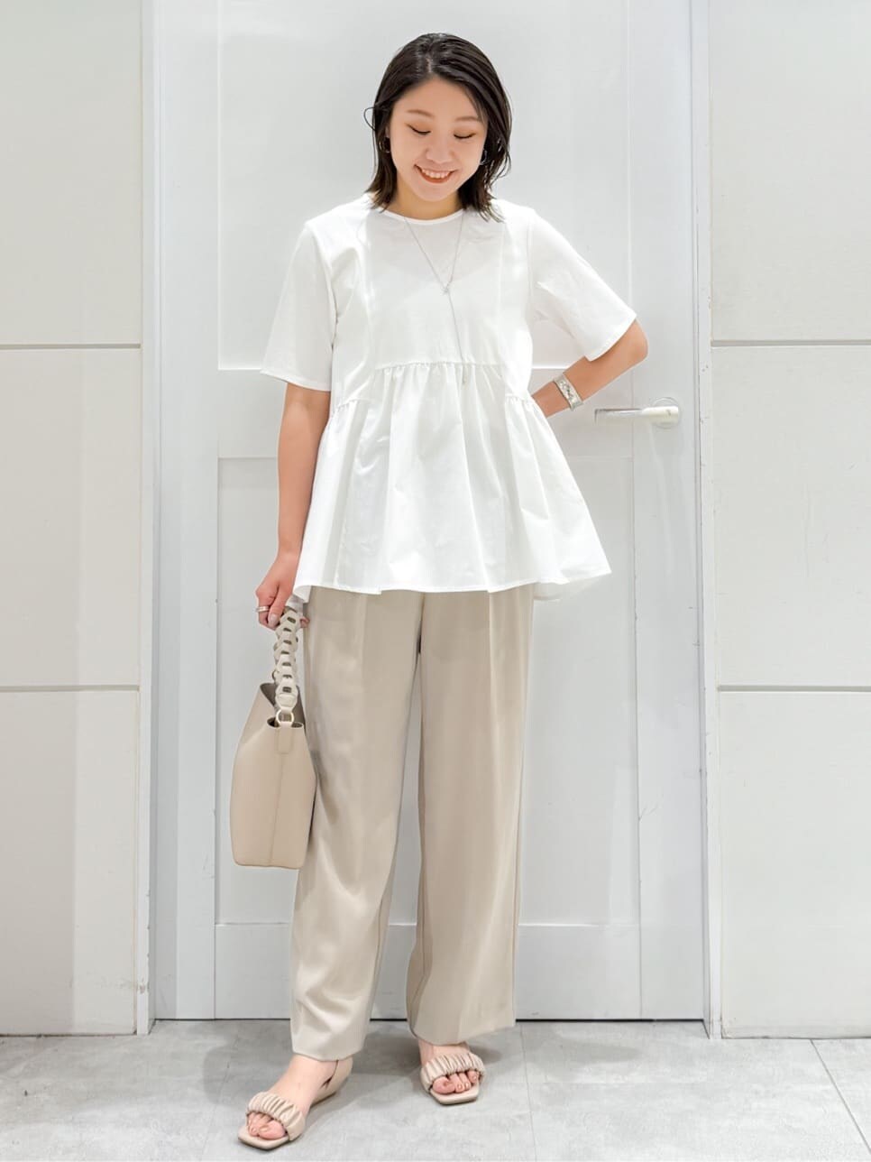 ホワイト系のTシャツ/カットソー、ベージュ系のその他パンツ、ベージュ系のショルダーバッグを着用したレディースの夏コーディネートの6枚目の写真