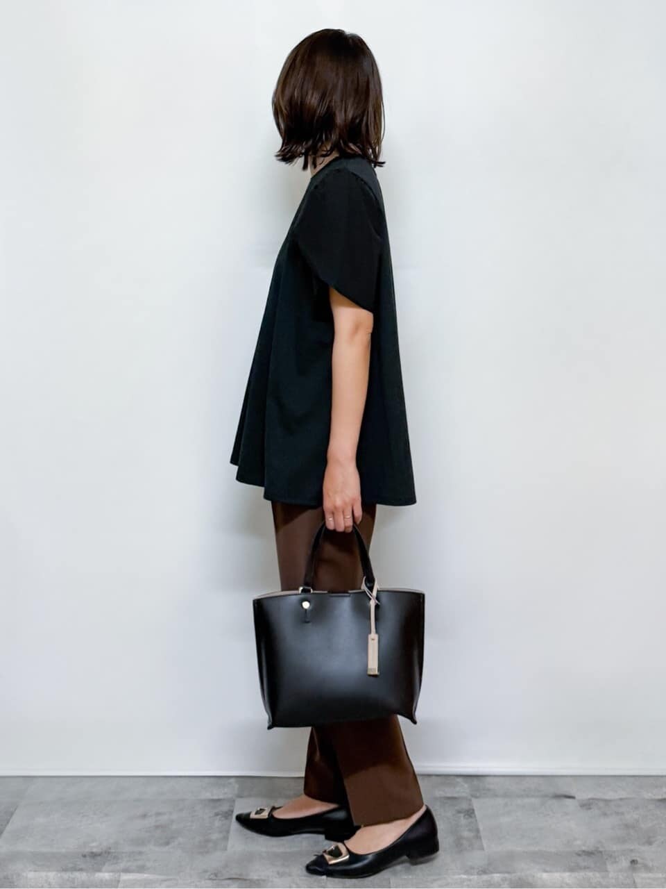 ブラック系のTシャツ/カットソー、ブラウン系のその他パンツ、ブラック系のトートバッグを着用したレディースの夏コーディネートの6枚目の写真