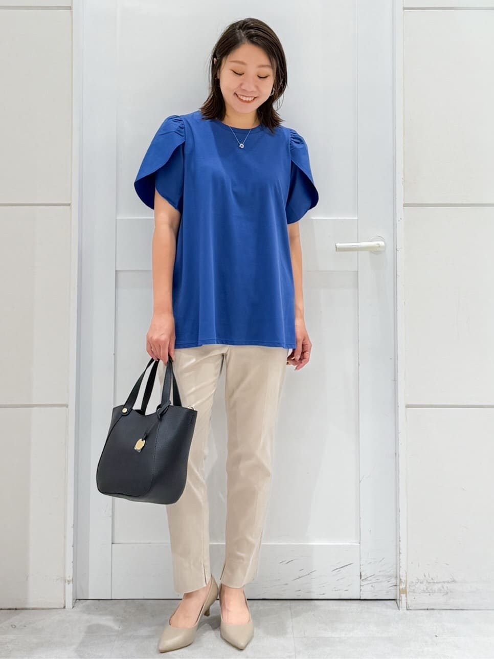 ブルー系のTシャツ/カットソー、ベージュ系のその他パンツ、ブラック系のトートバッグを着用したレディースの夏コーディネートの5枚目の写真