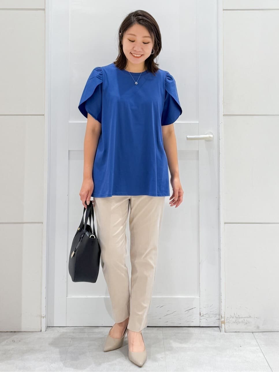 ブルー系のTシャツ/カットソー、ベージュ系のその他パンツ、ブラック系のトートバッグを着用したレディースの夏コーディネートの6枚目の写真
