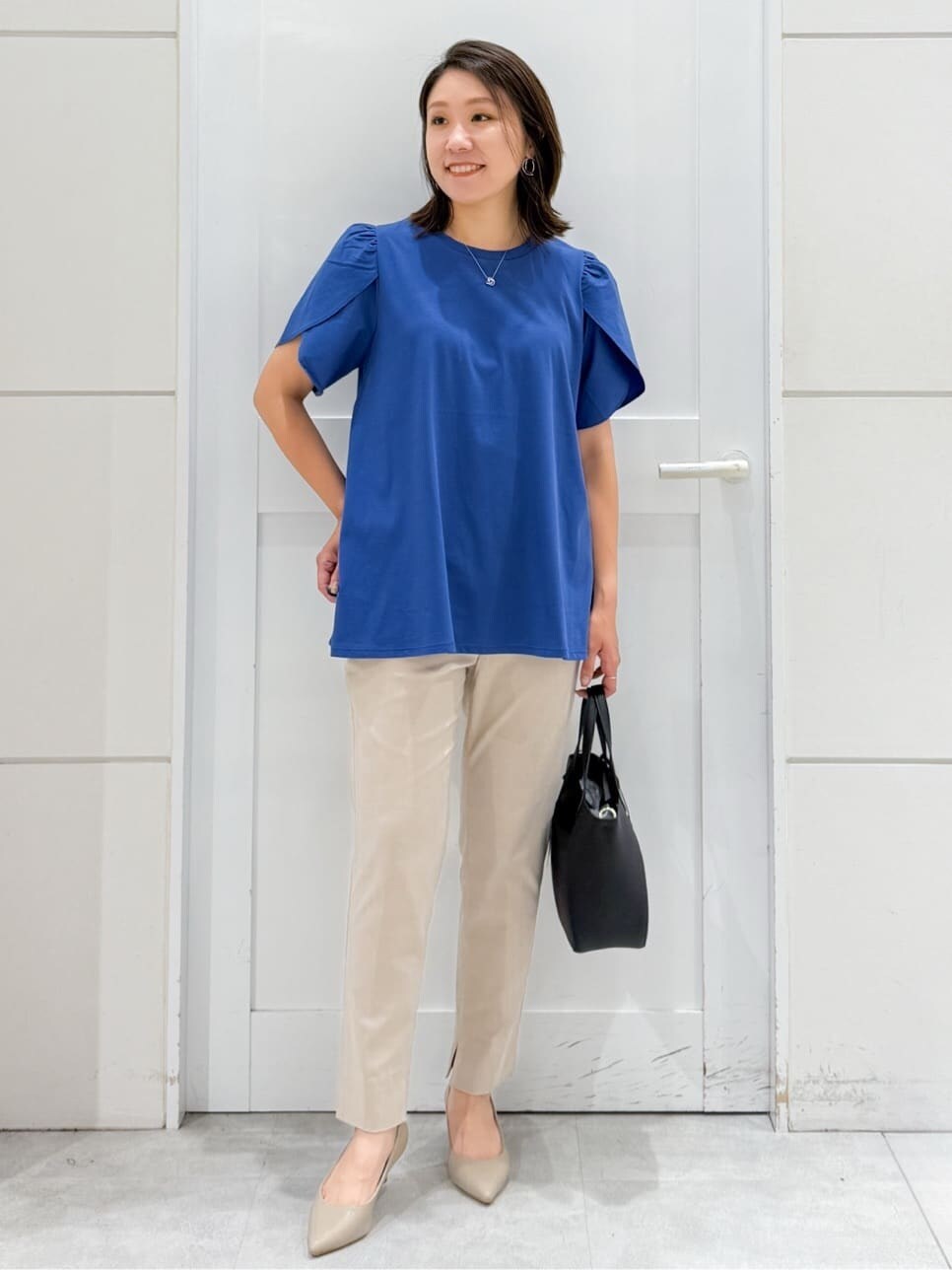 ブルー系のTシャツ/カットソー、ベージュ系のその他パンツ、ブラック系のトートバッグを着用したレディースの夏コーディネートの4枚目の写真