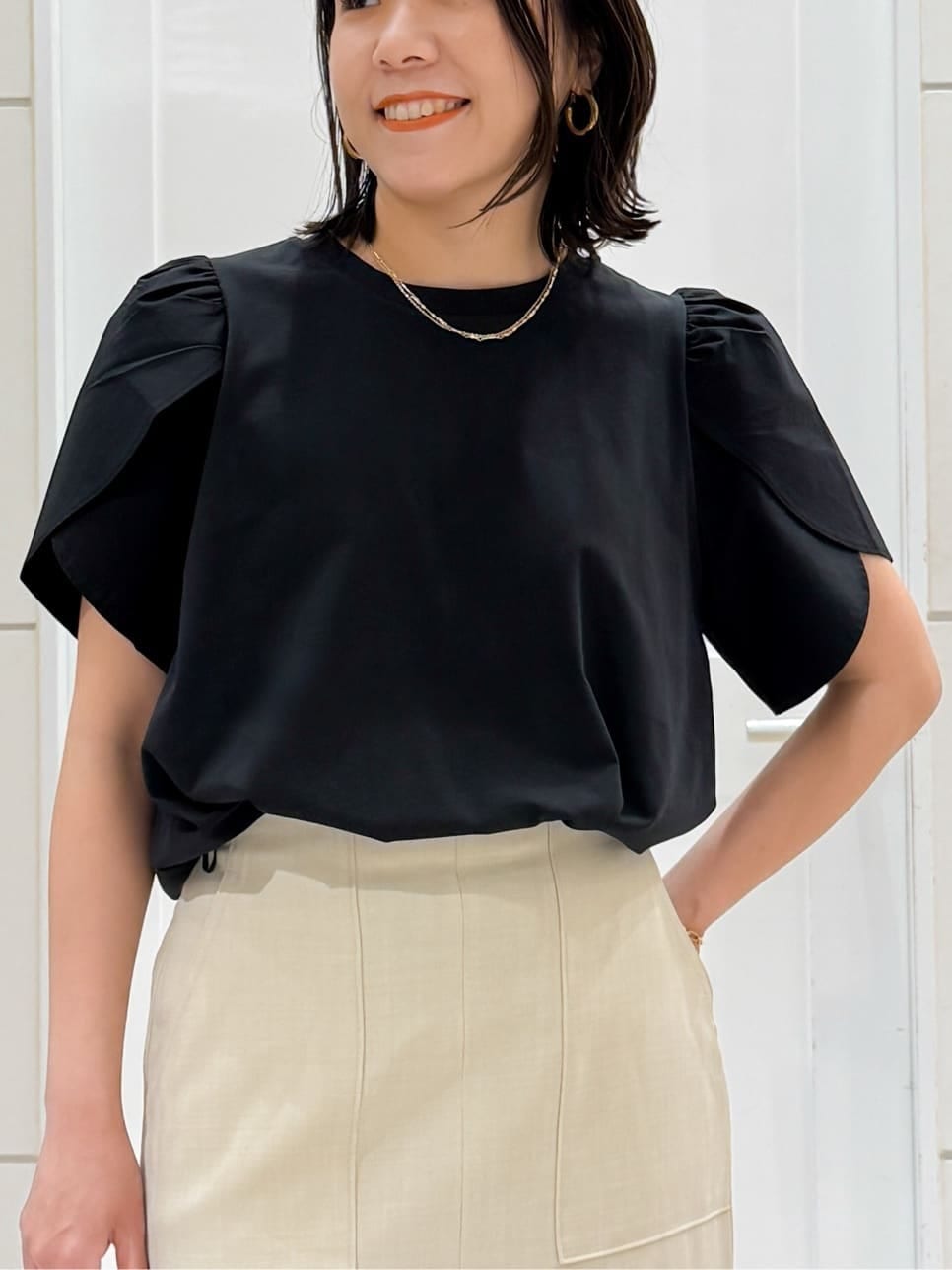 ブラック系のTシャツ/カットソー、ベージュ系のスカート、ホワイト系のショルダーバッグを着用したレディースの夏コーディネートの9枚目の写真
