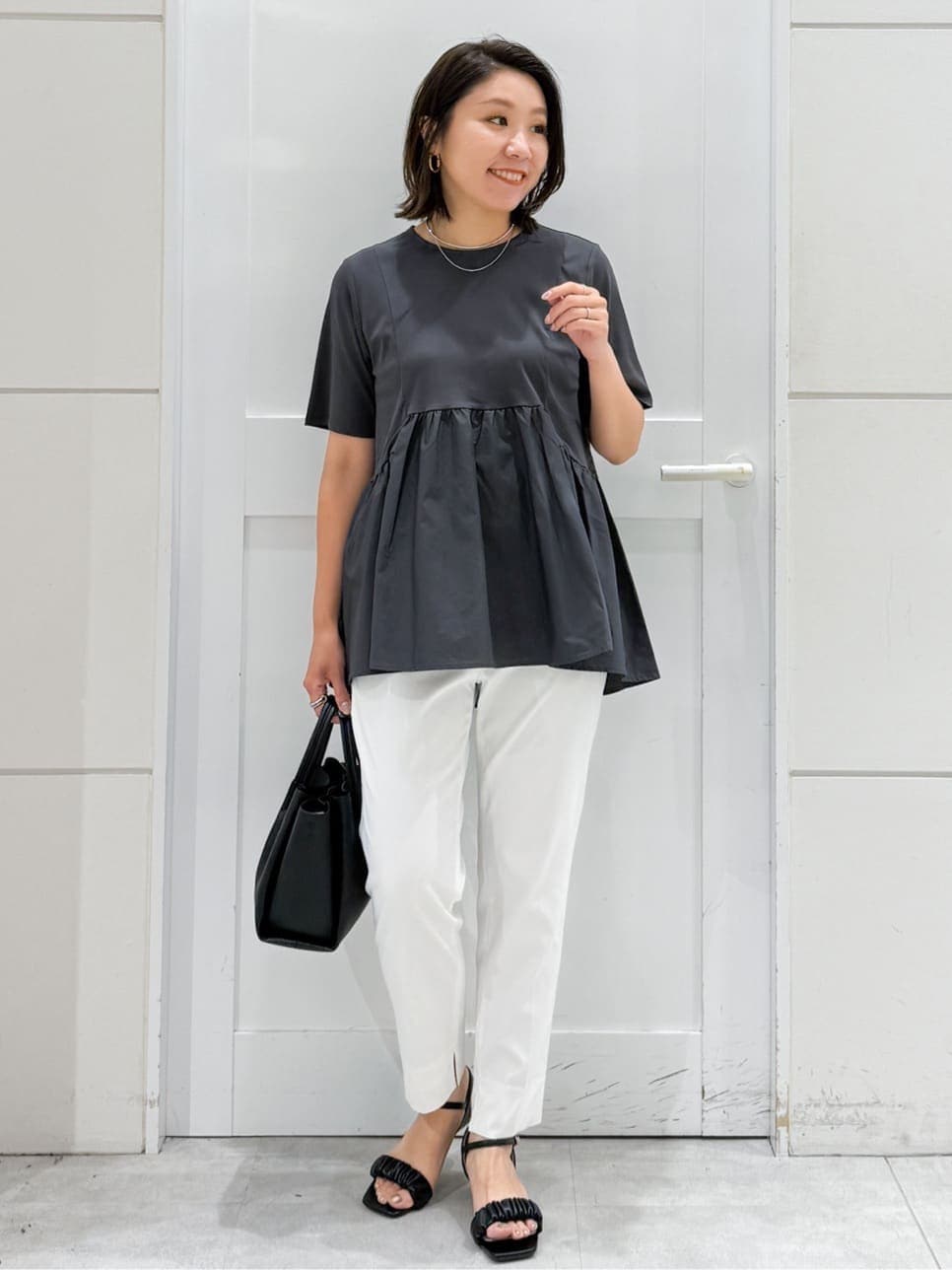 グレー系のTシャツ/カットソー、ホワイト系のその他パンツ、ブラック系のサンダルを着用したレディースの夏コーディネートの2枚目の写真