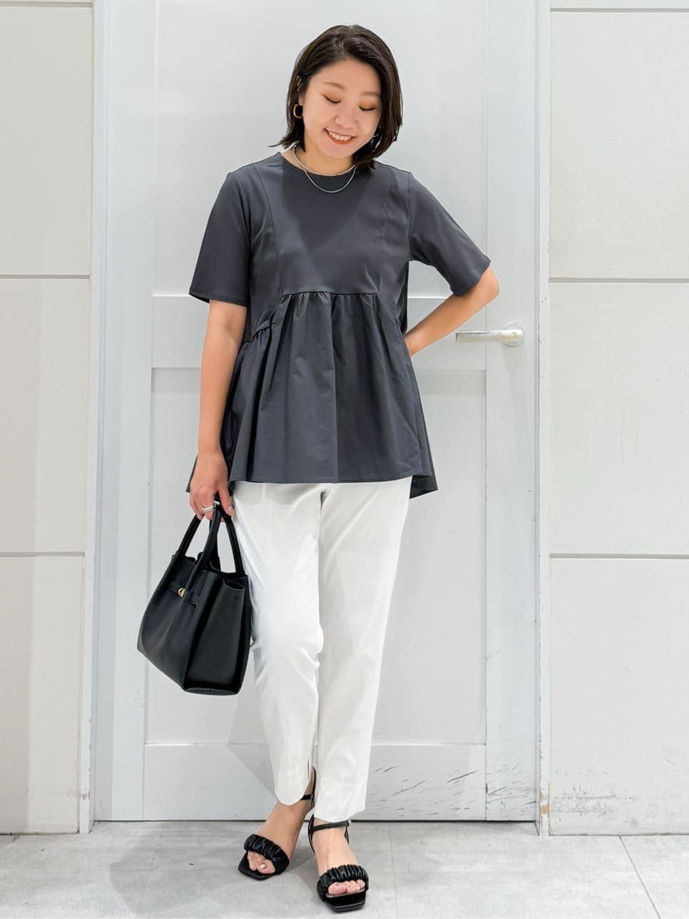グレー系のTシャツ/カットソー、ホワイト系のその他パンツ、ブラック系のサンダルを着用したレディースの夏コーディネートの3枚目の写真