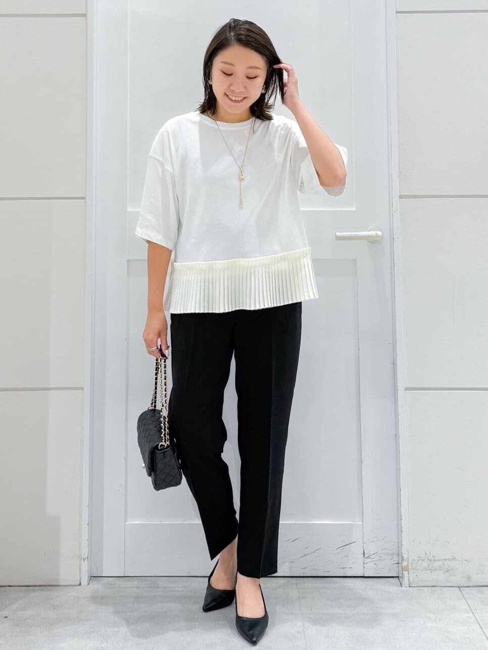 ホワイト系のTシャツ/カットソー、ブラック系のその他パンツ、ブラック系のショルダーバッグを着用したレディースの夏コーディネートの3枚目の写真
