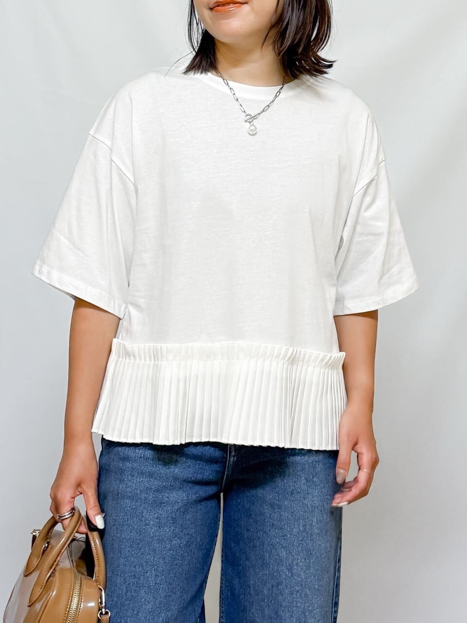 ホワイト系のTシャツ/カットソー、ブルー系のデニムパンツ、ベージュ系のショルダーバッグを着用したレディースの夏コーディネートの10枚目の写真