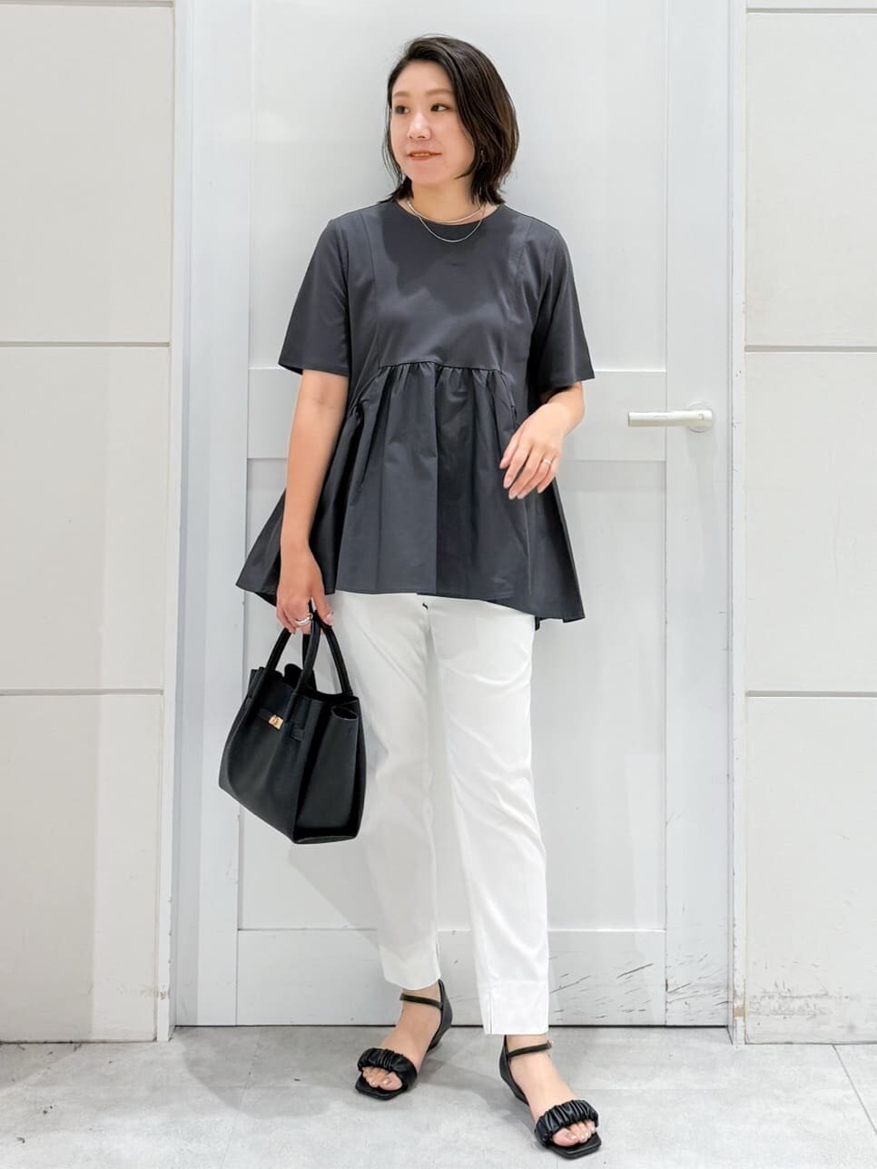 グレー系のTシャツ/カットソー、ホワイト系のその他パンツ、ブラック系のサンダルを着用したレディースの夏コーディネートの6枚目の写真