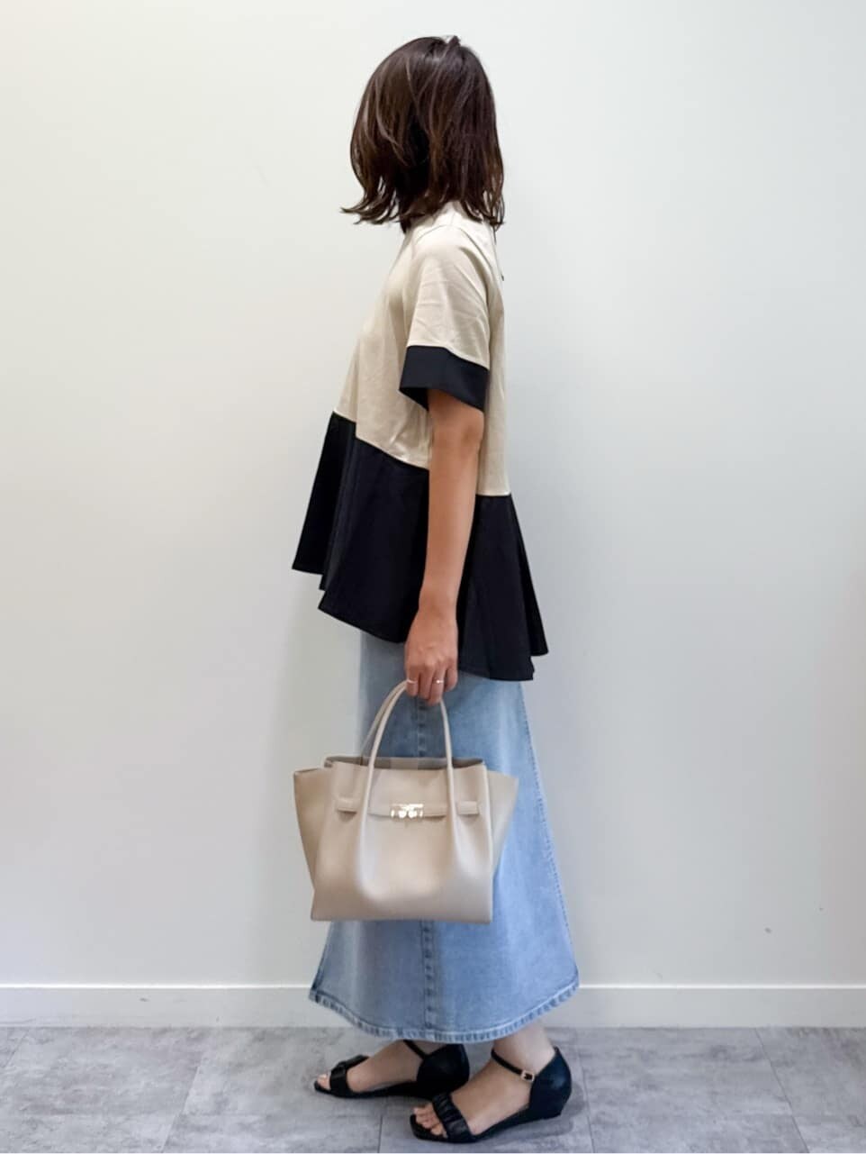 ベージュ系のTシャツ/カットソー、ブルー系のデニムスカート、ベージュ系のショルダーバッグを着用したレディースの夏コーディネートの7枚目の写真