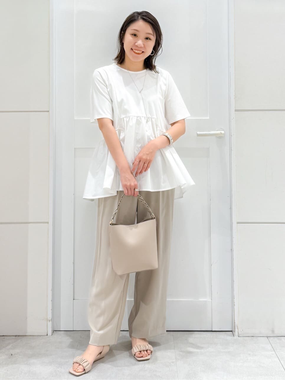 ホワイト系のTシャツ/カットソー、ベージュ系のその他パンツ、ベージュ系のショルダーバッグを着用したレディースの夏コーディネートの3枚目の写真