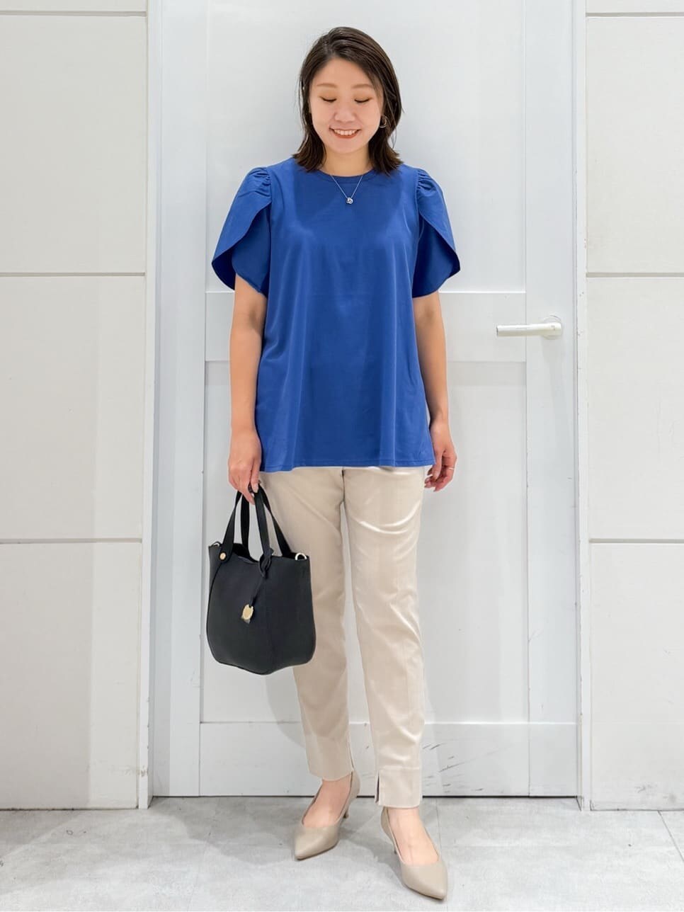 ブルー系のTシャツ/カットソー、ベージュ系のその他パンツ、ブラック系のトートバッグを着用したレディースの夏コーディネートの3枚目の写真