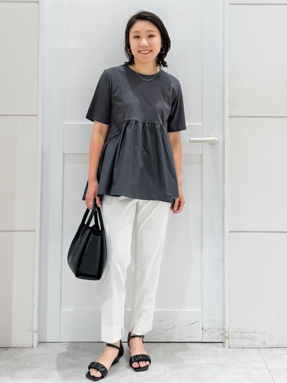 グレー系のTシャツ/カットソー、ホワイト系のその他パンツ、ブラック系のサンダルを着用したレディースの夏コーディネートの4枚目の写真