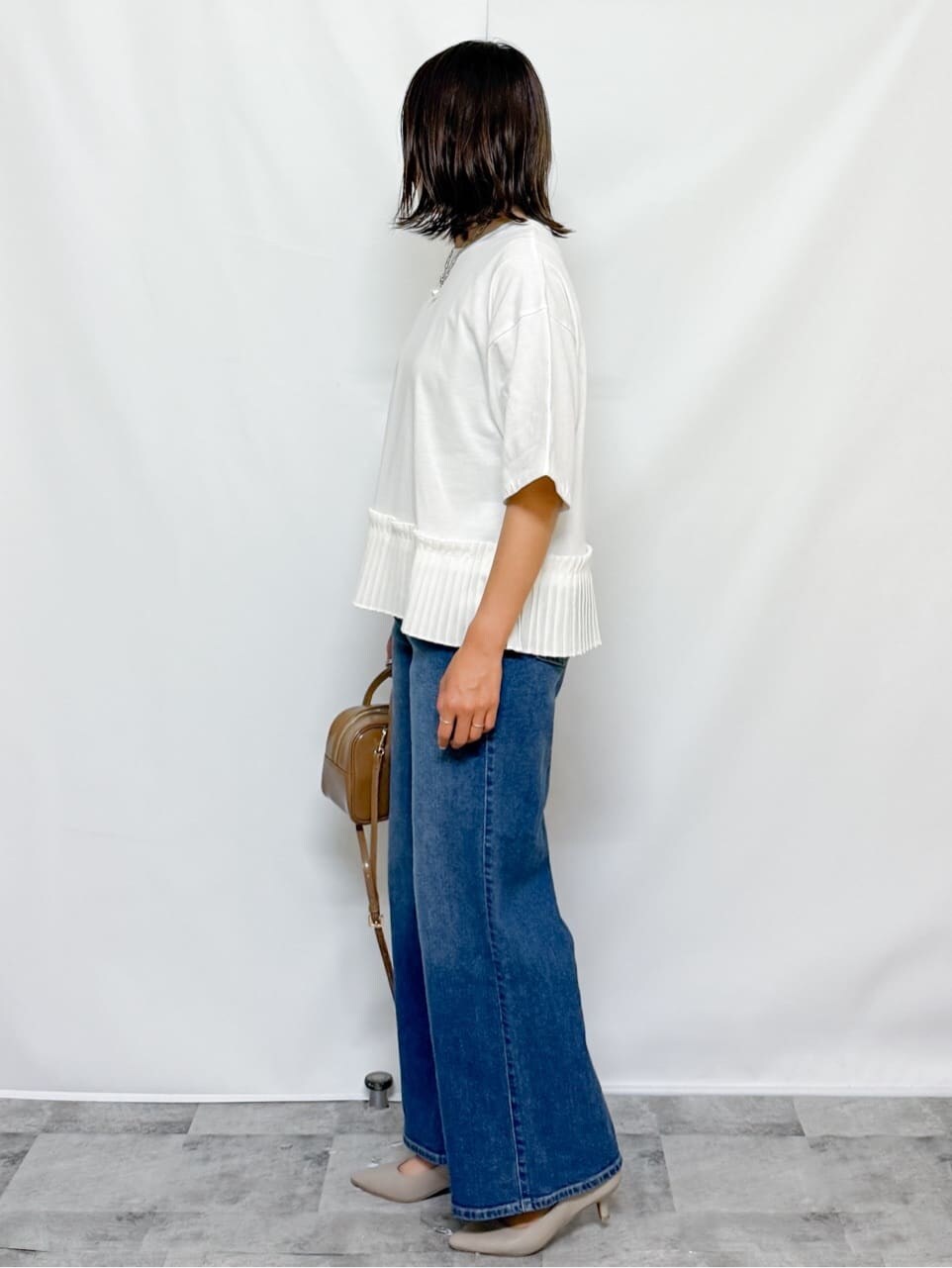 ホワイト系のTシャツ/カットソー、ブルー系のデニムパンツ、ベージュ系のショルダーバッグを着用したレディースの夏コーディネートの7枚目の写真
