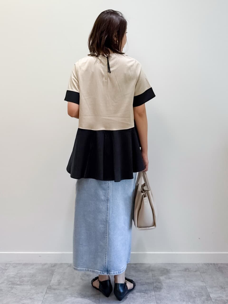 ベージュ系のTシャツ/カットソー、ブルー系のデニムスカート、ベージュ系のショルダーバッグを着用したレディースの夏コーディネートの9枚目の写真