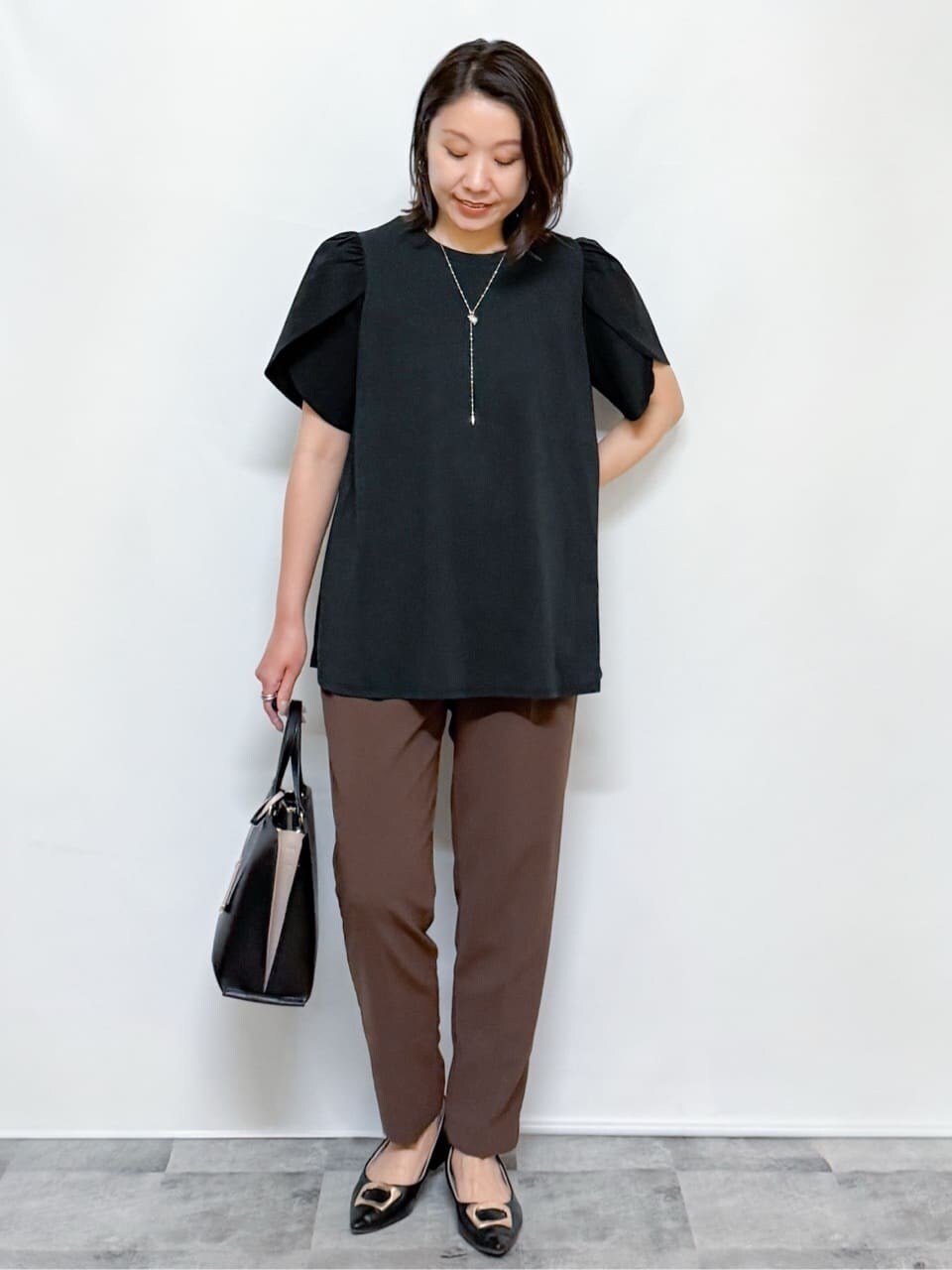 ブラック系のTシャツ/カットソー、ブラウン系のその他パンツ、ブラック系のトートバッグを着用したレディースの夏コーディネートの4枚目の写真