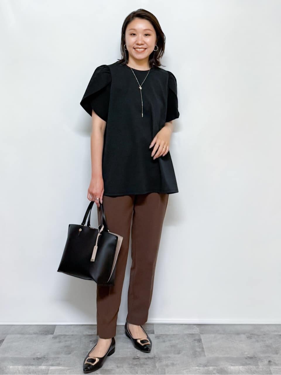 ブラック系のTシャツ/カットソー、ブラウン系のその他パンツ、ブラック系のトートバッグを着用したレディースの夏コーディネートの3枚目の写真