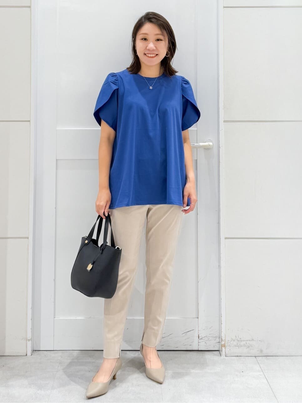ブルー系のTシャツ/カットソー、ベージュ系のその他パンツ、ブラック系のトートバッグを着用したレディースの夏コーディネートの2枚目の写真