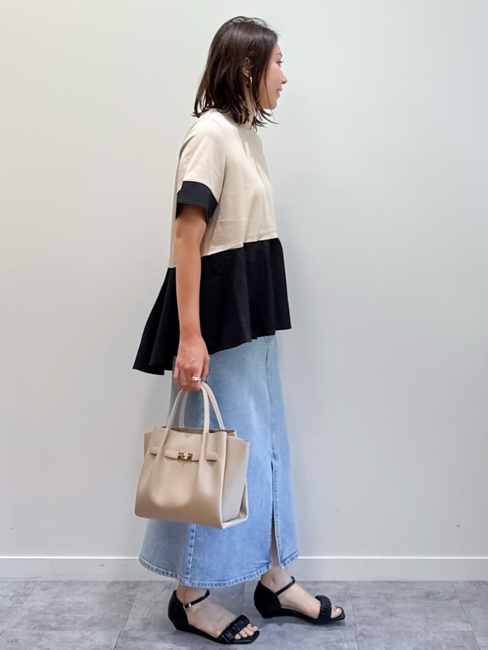 ベージュ系のTシャツ/カットソー、ブルー系のデニムスカート、ベージュ系のショルダーバッグを着用したレディースの夏コーディネートの8枚目の写真