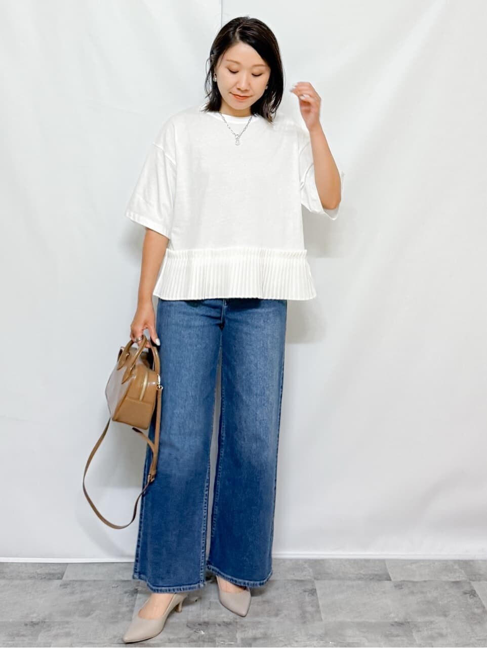 ホワイト系のTシャツ/カットソー、ブルー系のデニムパンツ、ベージュ系のショルダーバッグを着用したレディースの夏コーディネートの5枚目の写真
