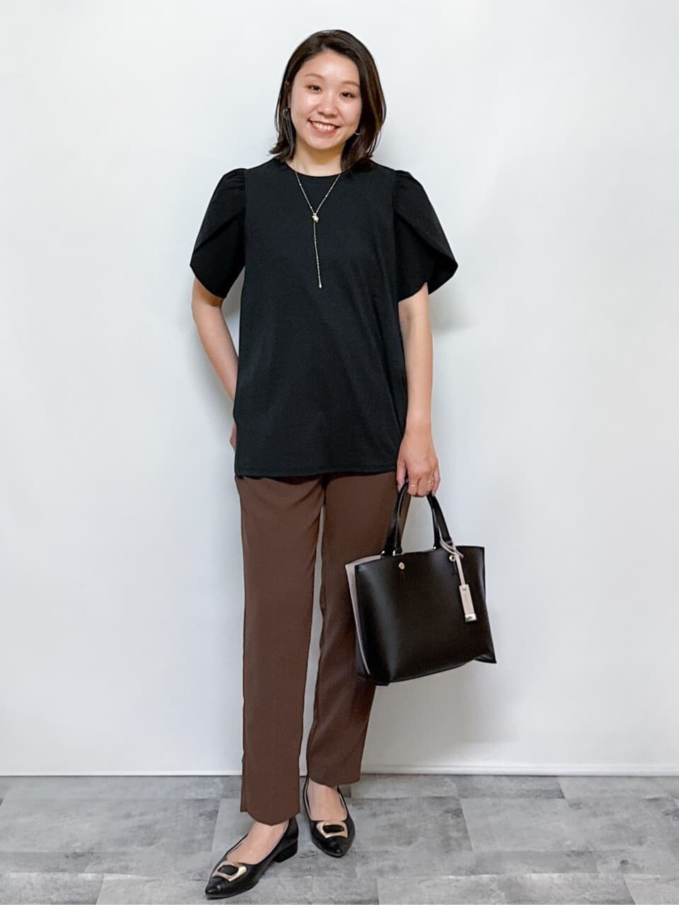 ブラック系のTシャツ/カットソー、ブラウン系のその他パンツ、ブラック系のトートバッグを着用したレディースの夏コーディネートの2枚目の写真