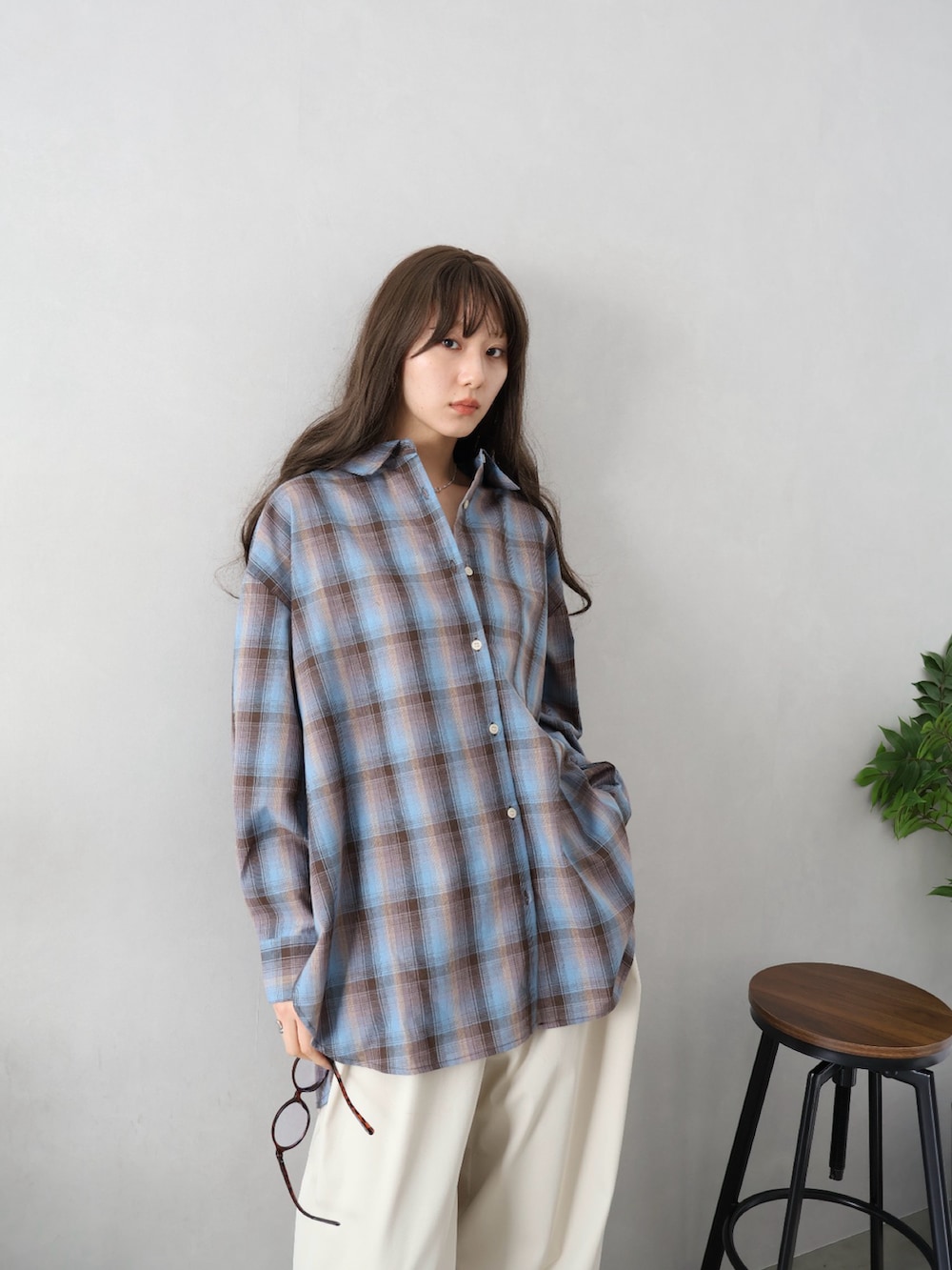 ブルー系のシャツ/ブラウス、ベージュ系のパンツを着用したレディースの春コーディネートの2枚目の写真