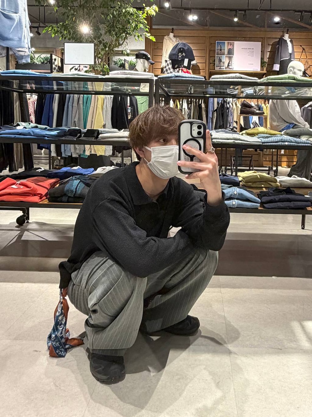 ブラック系のスニーカー、グレー系のスラックス、ブラック系のポロシャツを着用したメンズの春コーディネートの2枚目の写真