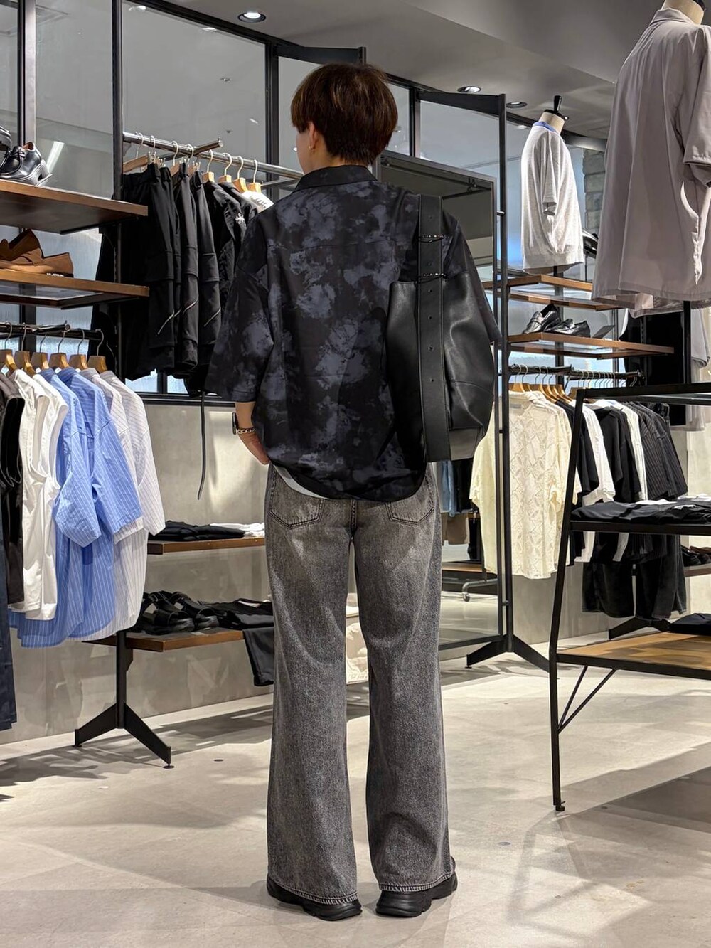 ブラック系のTシャツ/カットソー、グレー系のデニムパンツ、ブラック系のサンダルを着用したメンズの夏コーディネートの4枚目の写真