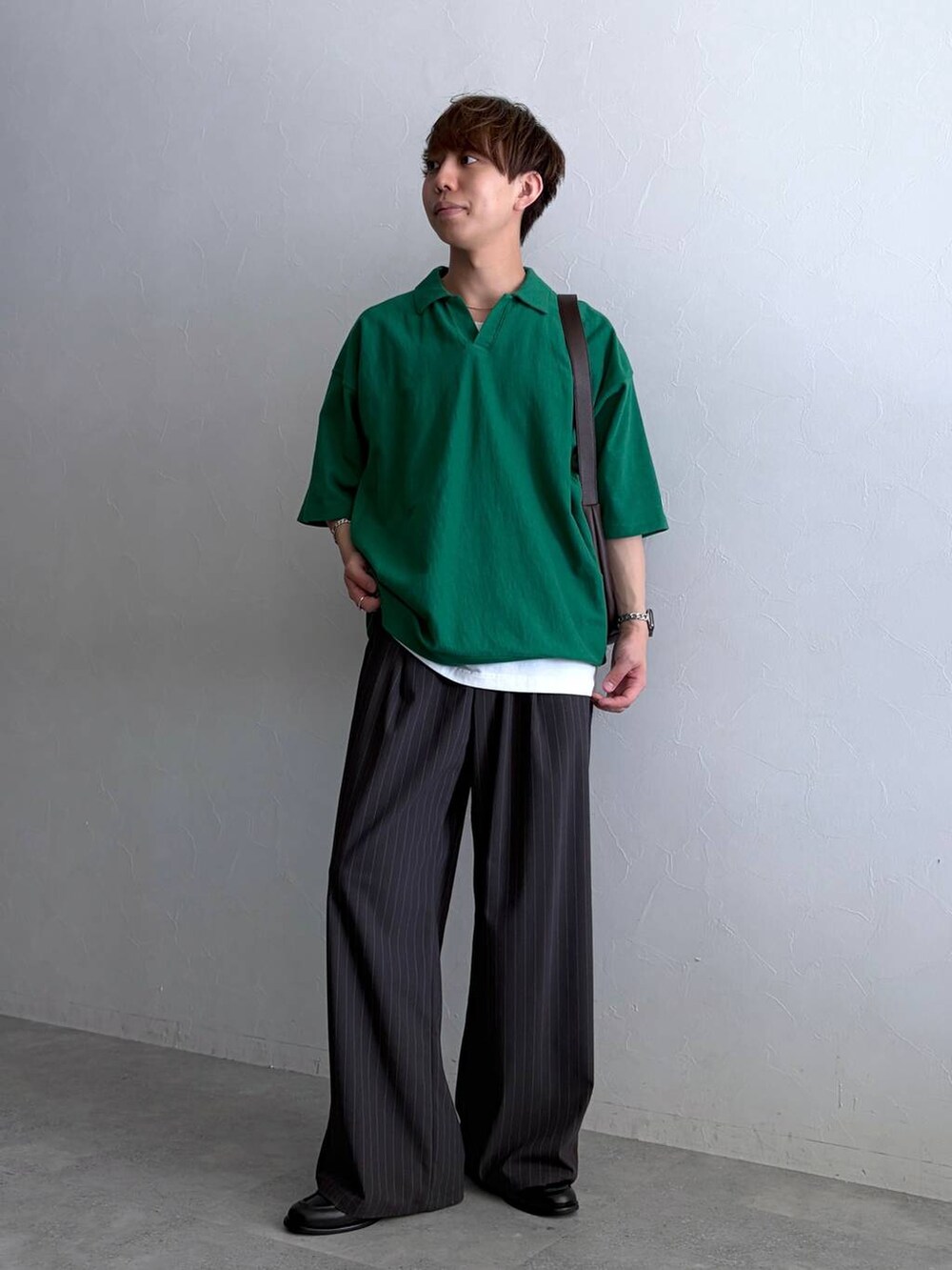 グリーン系のTシャツ/カットソー、ブラック系のローファー、グレー系のスラックスを着用したメンズの夏コーディネートの2枚目の写真