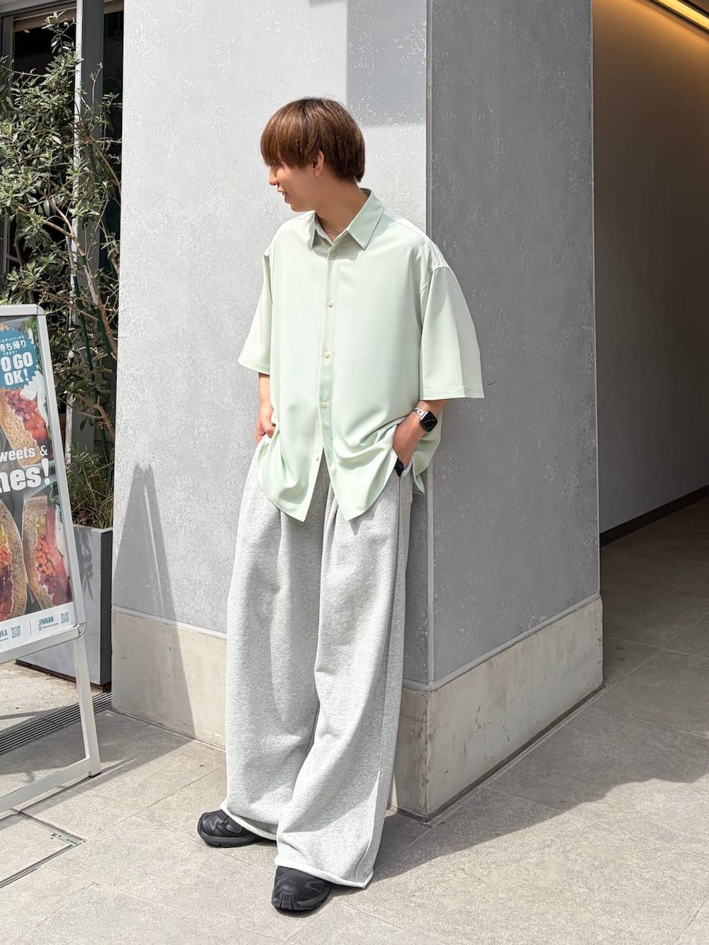 グリーン系のシャツ/ブラウス、ブラック系のスニーカー、グレー系のスウェットパンツを着用したメンズの春コーディネートの3枚目の写真