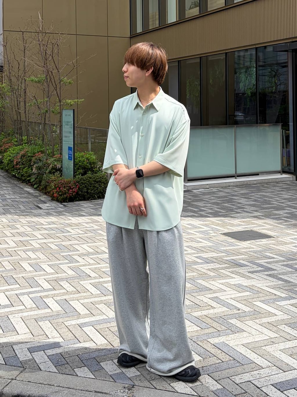 グリーン系のシャツ/ブラウス、ブラック系のスニーカー、グレー系のスウェットパンツを着用したメンズの春コーディネートの5枚目の写真