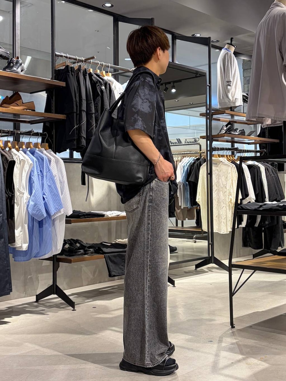 ブラック系のTシャツ/カットソー、グレー系のデニムパンツ、ブラック系のサンダルを着用したメンズの夏コーディネートの3枚目の写真