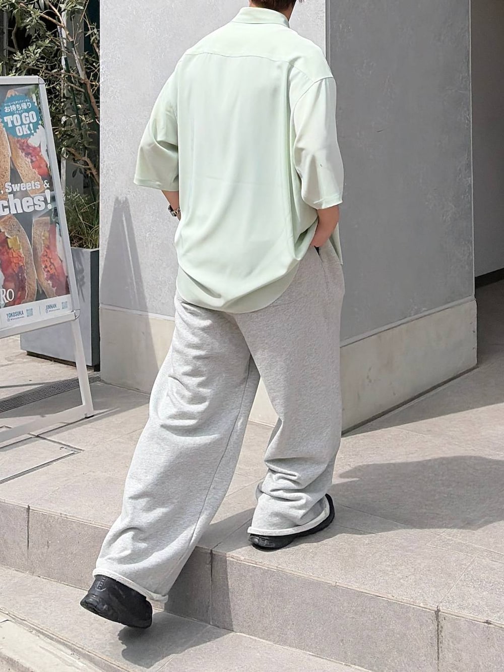 グリーン系のシャツ/ブラウス、ブラック系のスニーカー、グレー系のスウェットパンツを着用したメンズの春コーディネートの4枚目の写真