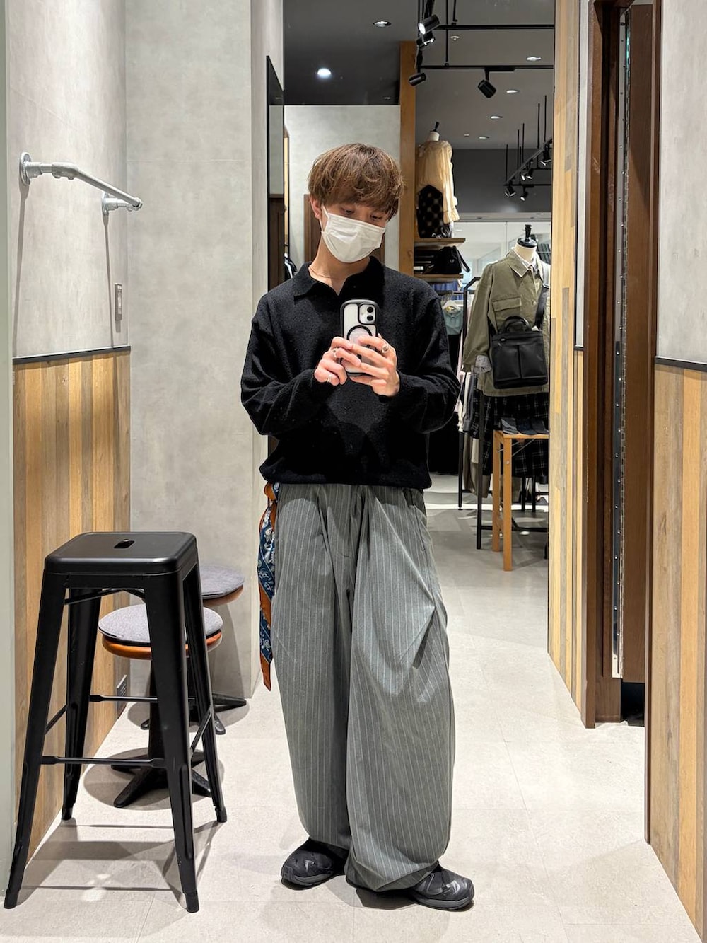 ブラック系のスニーカー、グレー系のスラックス、ブラック系のポロシャツを着用したメンズの春コーディネートの3枚目の写真