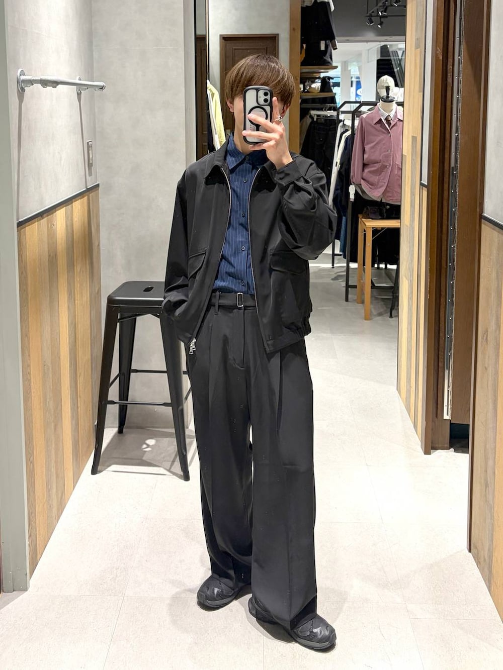 ブラック系のスニーカー、ブラック系のスラックス、ブラック系のブルゾンを着用したメンズの春コーディネートの2枚目の写真