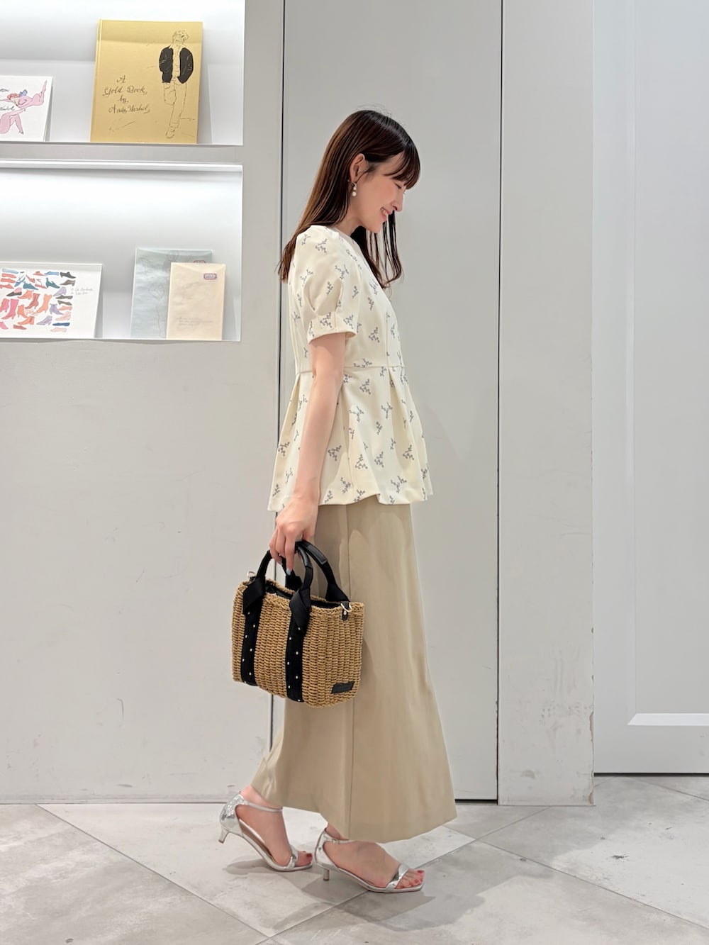 ホワイト系のシャツ/ブラウス、ベージュ系のスカート、ブラック系のかごバッグを着用したレディースの夏コーディネートの2枚目の写真