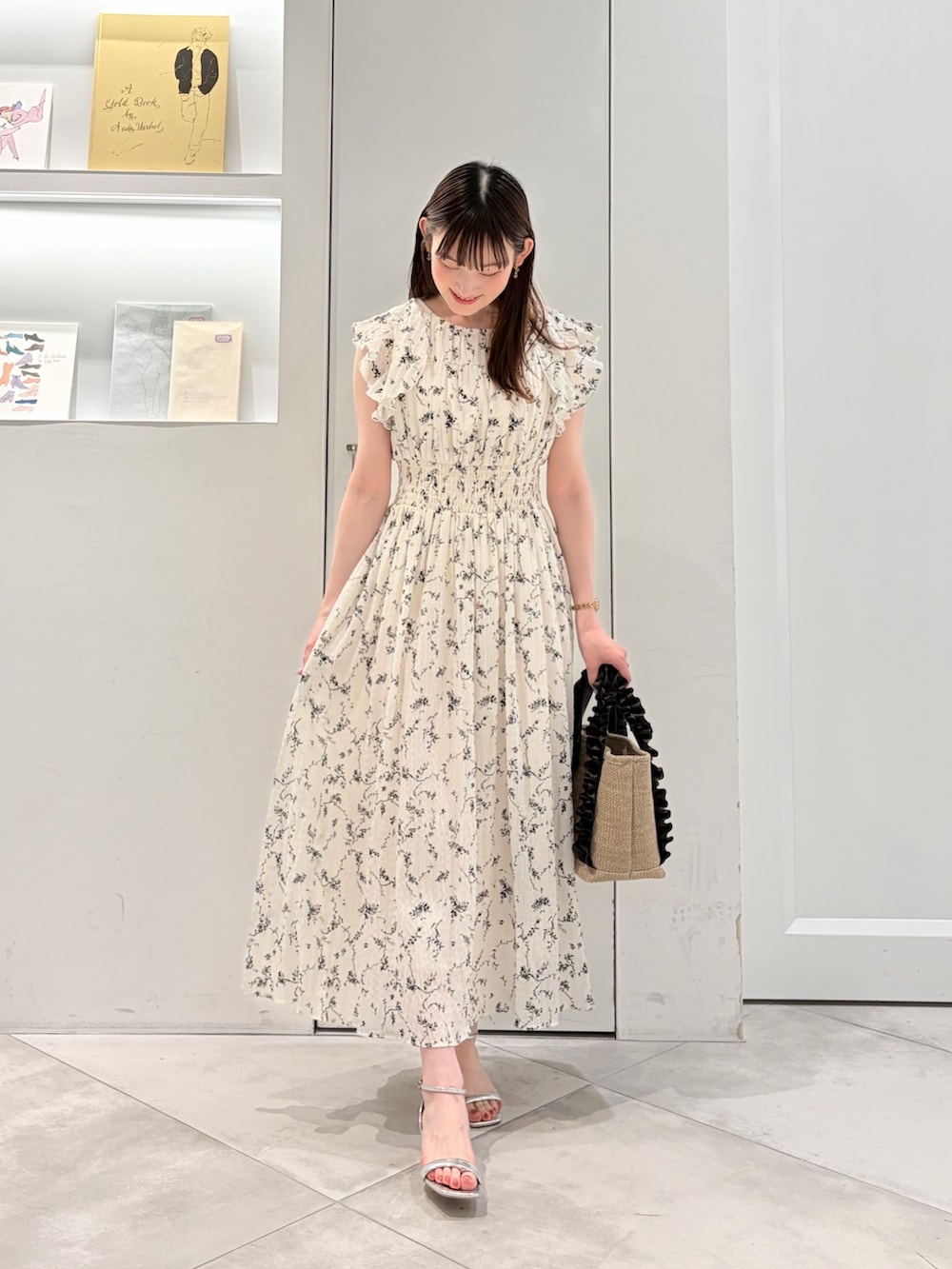 ホワイト系のワンピース、ブラウン系のトートバッグを着用したレディースの夏コーディネートの2枚目の写真