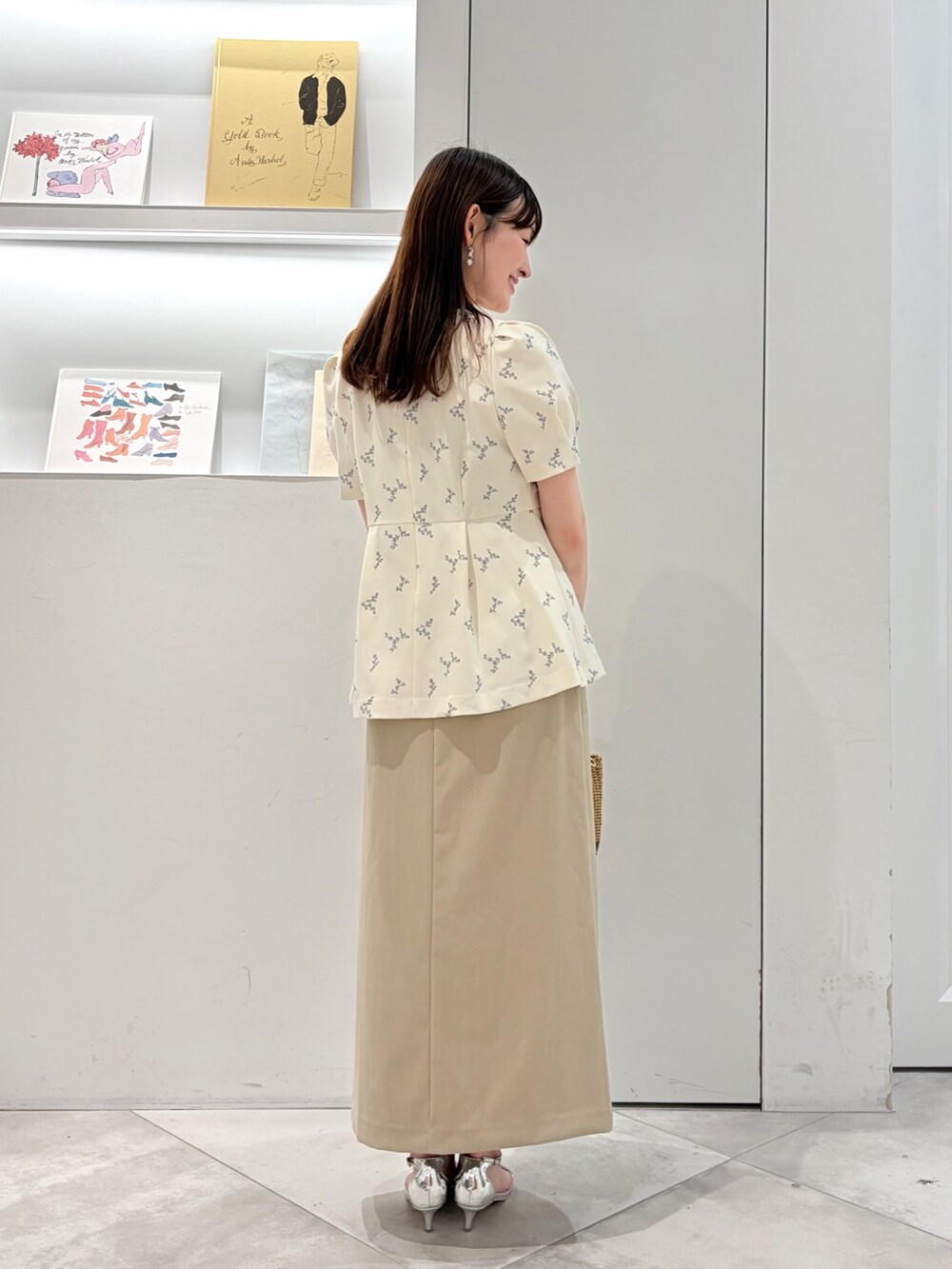 ホワイト系のシャツ/ブラウス、ベージュ系のスカート、ブラック系のかごバッグを着用したレディースの夏コーディネートの3枚目の写真