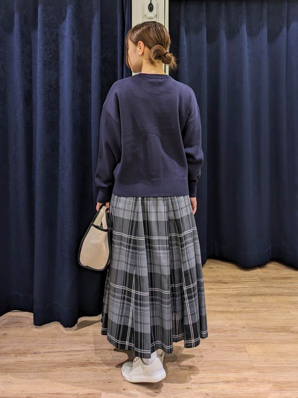 ブルー系のニット/セーター、グリーン系のスカート、ブラック系のショルダーバッグを着用したレディースの春コーディネートの3枚目の写真
