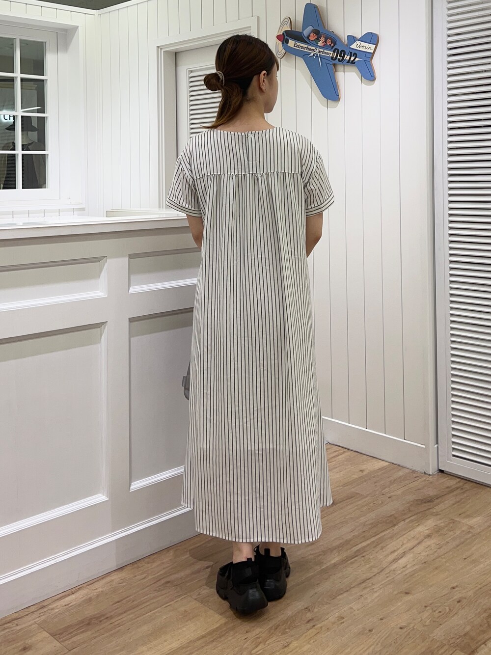 ブラウン系のカーディガン/ボレロ、ホワイト系のワンピース、ブラック系のサンダルを着用したレディースの春コーディネートの5枚目の写真