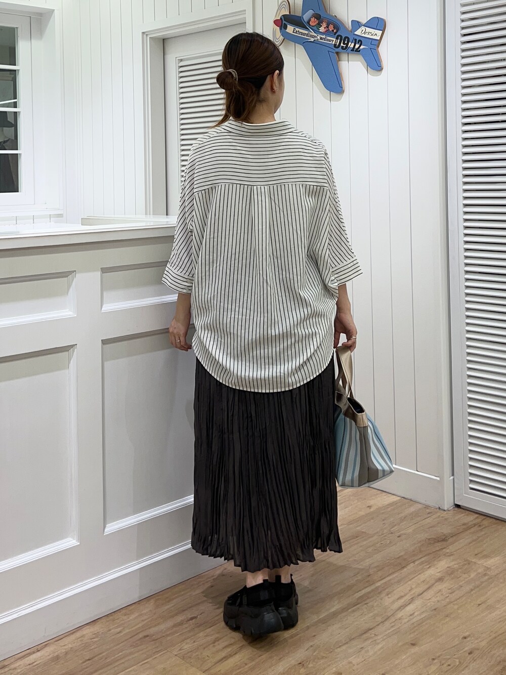 ホワイト系のシャツ/ブラウス、グレー系のスカート、ブラック系のサンダルを着用したレディースの春コーディネートの3枚目の写真