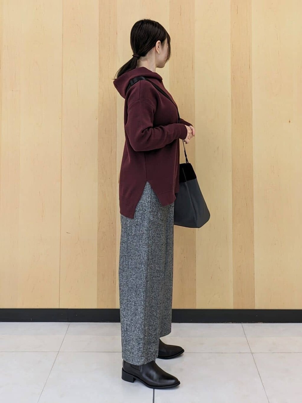 ブラック系のニット/セーター、レッド系のニット/セーター、ブラック系のその他パンツを着用したレディースの冬コーディネートの2枚目の写真