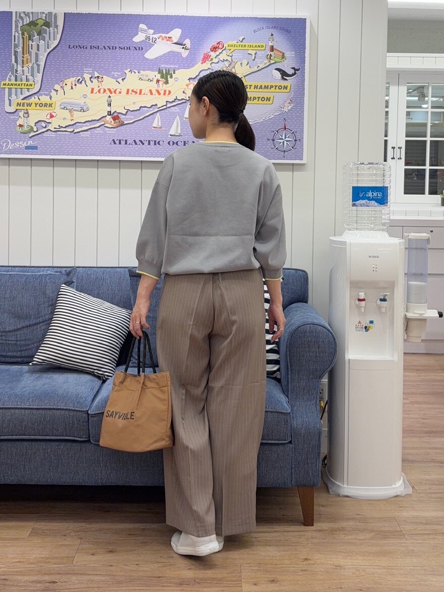 グレー系のニット/セーター、ブラウン系のその他パンツ、イエロー系のトートバッグを着用したレディースの夏コーディネートの3枚目の写真