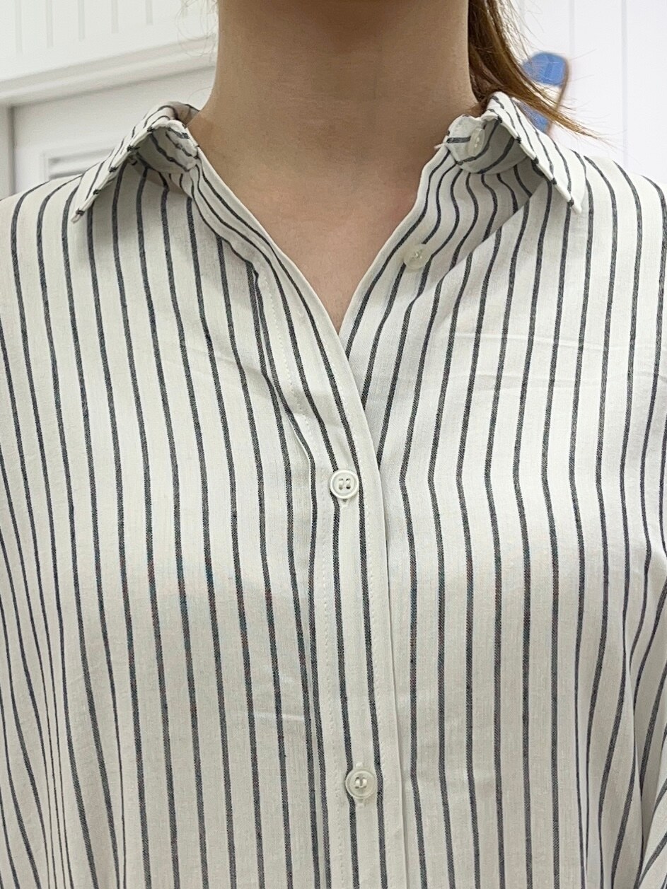 ホワイト系のシャツ/ブラウス、グレー系のスカート、ブラック系のサンダルを着用したレディースの春コーディネートの5枚目の写真