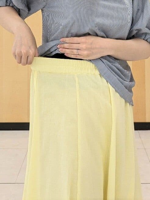 ベージュ系のシャツ/ブラウス、イエロー系のスカート、ベージュ系のトートバッグを着用したレディースの夏コーディネートの6枚目の写真