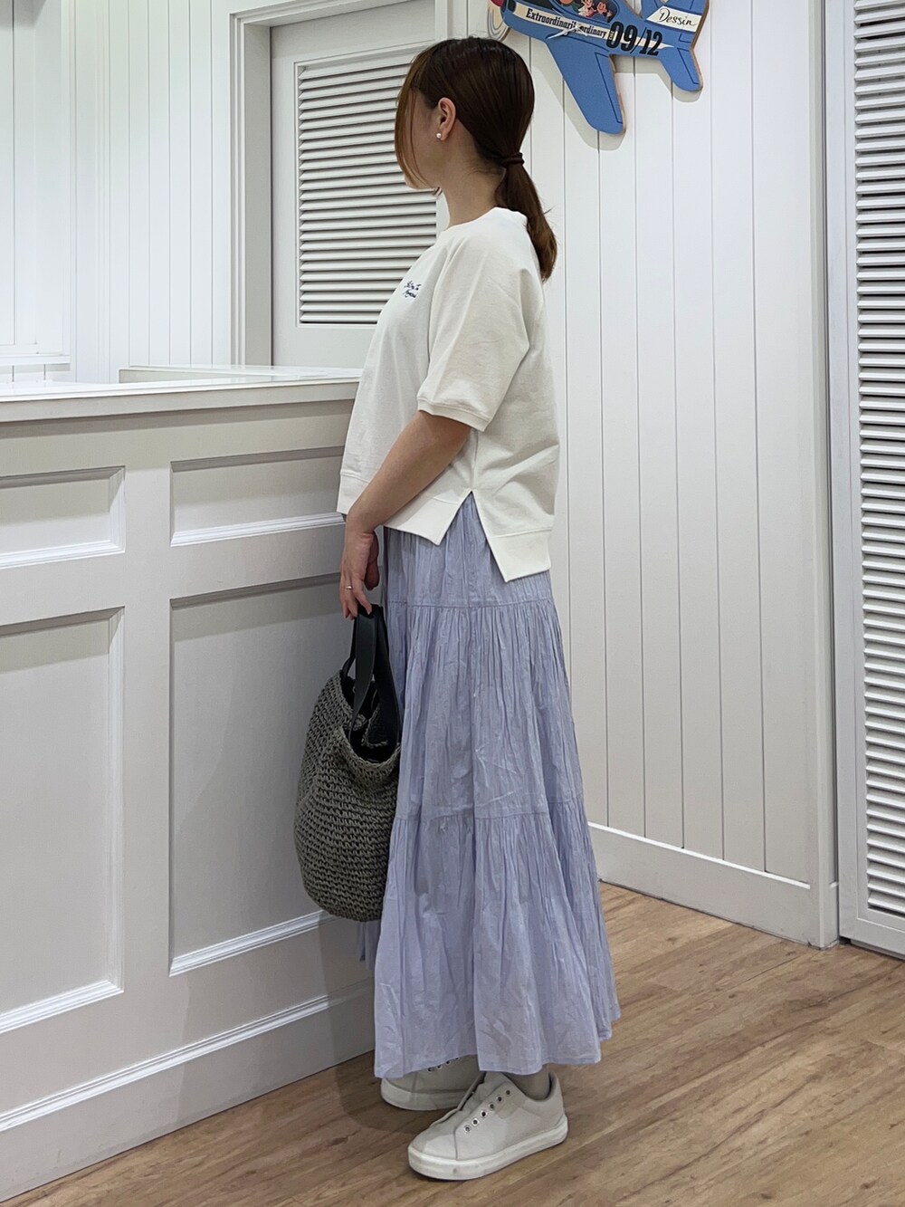 ホワイト系のTシャツ/カットソー、ブルー系のスカート、グレー系のトートバッグを着用したレディースの春コーディネートの2枚目の写真