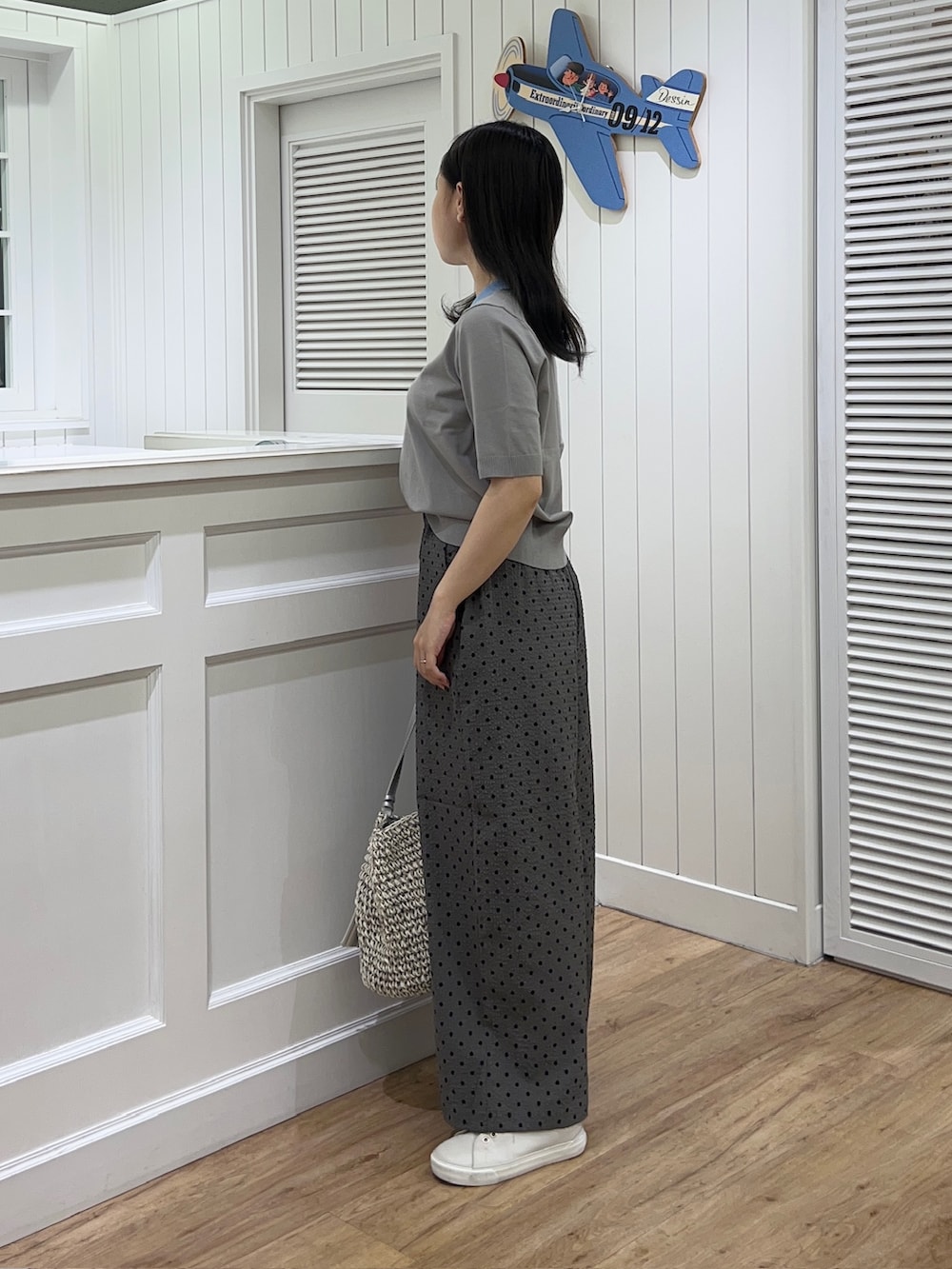 ブラウン系のニット/セーター、グレー系のその他パンツ、グレー系のトートバッグを着用したレディースの夏コーディネートの2枚目の写真