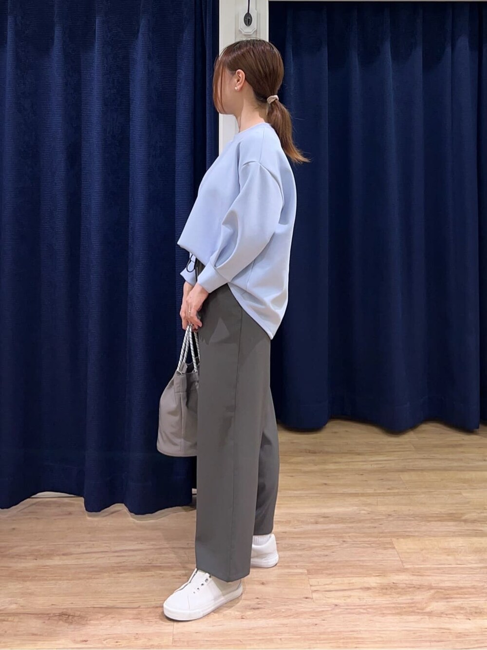 ブルー系のTシャツ/カットソー、グレー系のその他パンツ、グレー系のトートバッグを着用したレディースの春コーディネートの2枚目の写真