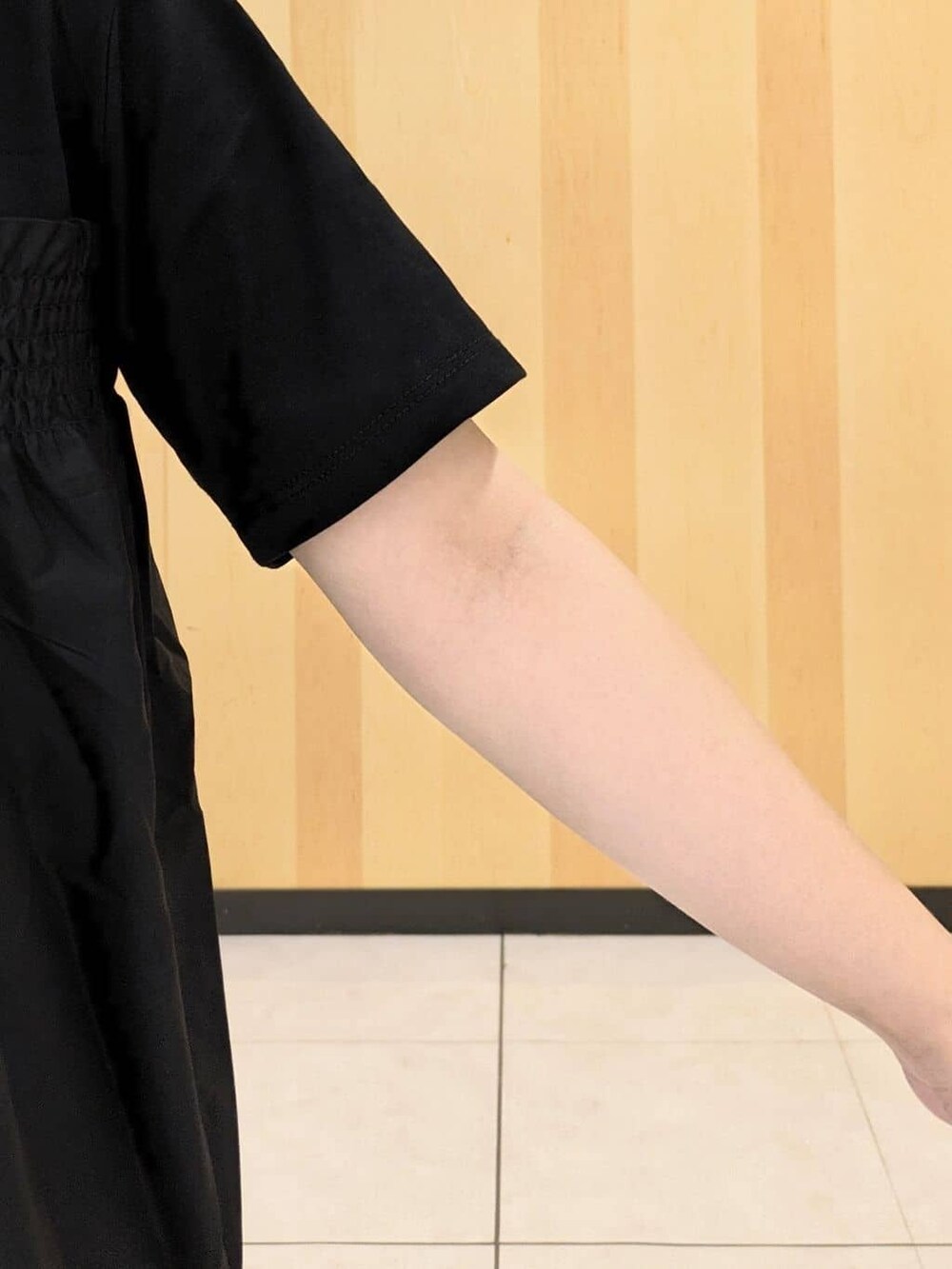 ブラック系のTシャツ/カットソー、ブルー系のスカート、ブラック系のショルダーバッグを着用したレディースの秋コーディネートの6枚目の写真