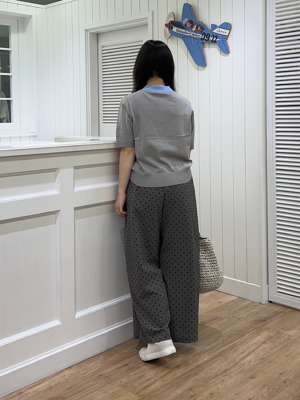 ブラウン系のニット/セーター、グレー系のその他パンツ、グレー系のトートバッグを着用したレディースの夏コーディネートの3枚目の写真