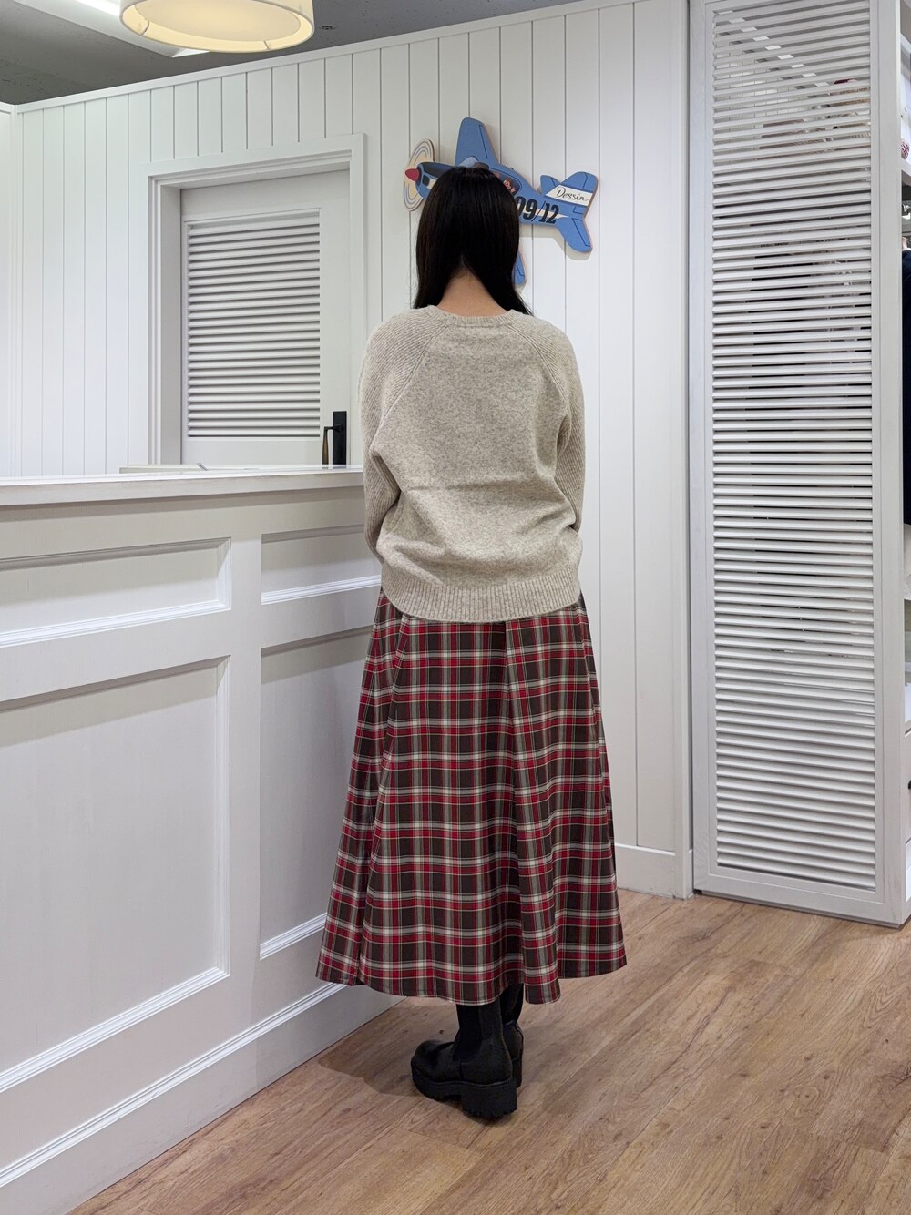 ベージュ系のニット/セーター、レッド系のスカート、ベージュ系のトートバッグを着用したレディースの秋コーディネートの3枚目の写真